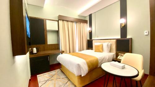 um quarto de hotel com uma cama e uma pequena mesa em Concorde Inn Hotel no Dubai