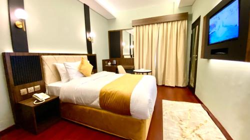 a hotel room with a bed and a television at Concorde Inn Hotel in Dubai