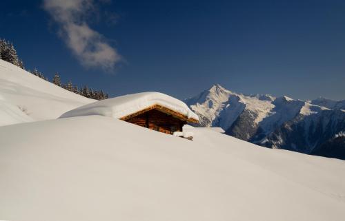 a snow covered cabin on top of a snow covered mountain at Apart Emilie in Mayrhofen