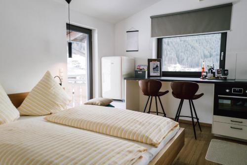 sypialnia z łóżkiem oraz kuchnia z blatem w obiekcie Spatla w mieście Gaschurn