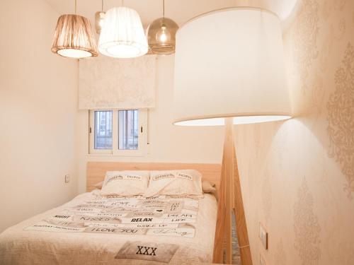 een kleine slaapkamer met een bed en 2 verlichting bij Apartamento Turistico Cava Alta in Madrid