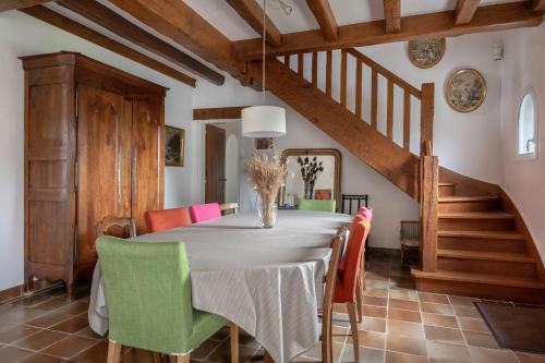 une salle à manger avec une table et des chaises vertes dans l'établissement Belle maison chaleureuse pour 14 personnes, à Mesquer