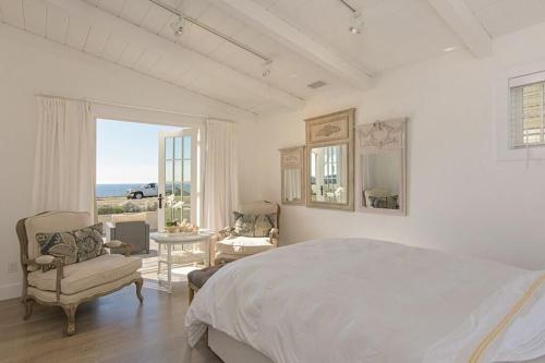 a white bedroom with a bed and a view of the ocean at Ocean Views, Across The Street From Beach, Private Patio in Carlsbad