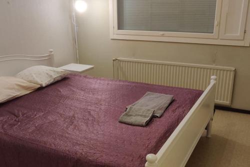 Una cama con un edredón morado encima. en Mediocre budget 2 rm apartment in Merirauma, en Rauma