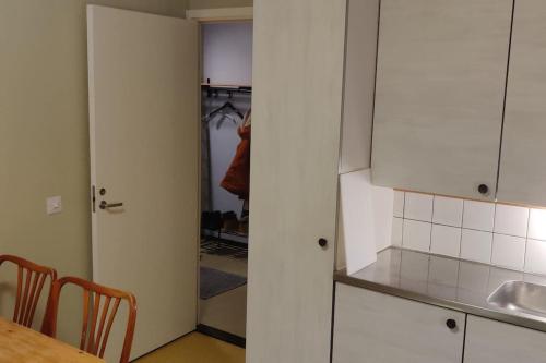 een keuken met witte kasten en een tafel en een deur bij Mediocre budget 2 rm apartment in Merirauma in Rauma