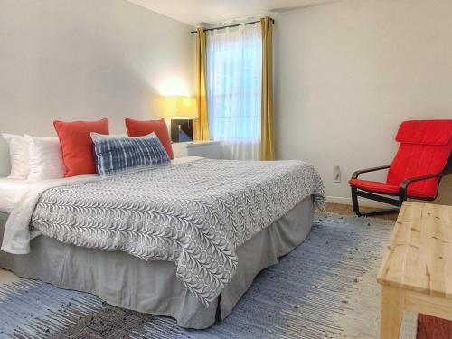 a bedroom with a bed and a red chair at Pet-friendly Duplex, Big Shared Yard in Charming Historic Travis Heights! in Austin