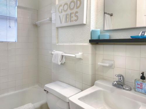 a white bathroom with a toilet and a sink at Pet-friendly Duplex, Big Shared Yard in Charming Historic Travis Heights! in Austin