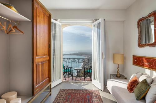 a living room with a bed and a large window at Hotel Villa Paradiso in Taormina