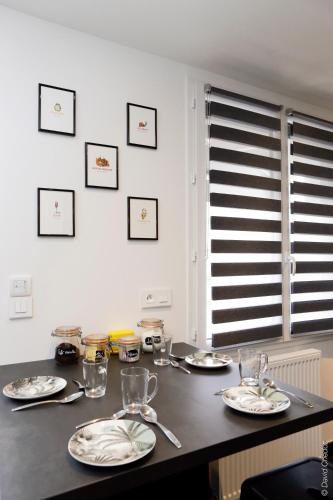 a table with plates and glasses on top of it at Maison « De Ville en Vigne » in Chenôve