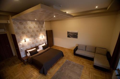 - une chambre avec un lit, une chaise et un canapé dans l'établissement SasOne Rooms, à Budapest