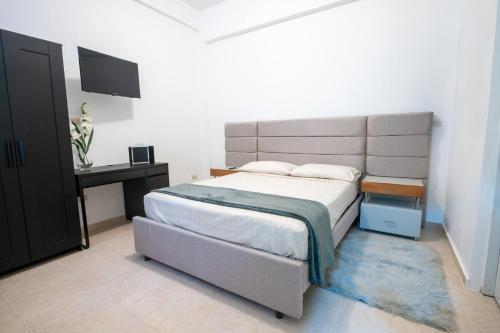 ein Schlafzimmer mit einem großen Bett und einem TV in der Unterkunft Estudio 9 en la Zona Colonial in Santo Domingo