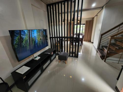 a living room with a large flat screen tv at Baguio Hillside Haven in Baguio