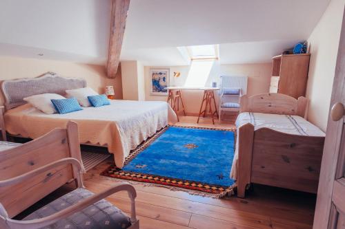 a bedroom with two beds and a blue rug at B&B en Provence- Villa Saint Marc in Forcalquier