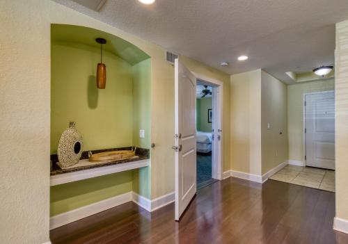 un corridoio di una casa con pareti verdi e lavandino di New Hotel Collection Harbourside a Clearwater Beach