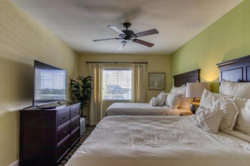 1 dormitorio con 2 camas y ventilador de techo en New Hotel Collection Harbourside, en Clearwater Beach
