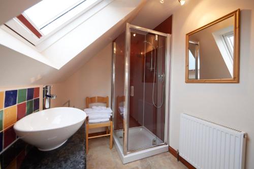a bathroom with a white sink and a shower at The Mews Apartment at Daviot Lodge in Inverness