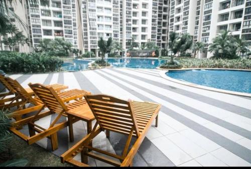 a group of chairs sitting next to a swimming pool at COUNTRY GARDEN@J Agape Homestay STUDIO 3C in Johor Bahru