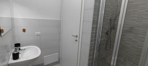 Un baño blanco con lavabo y ducha. en Appartamento Mare&Castello, en Castelsardo