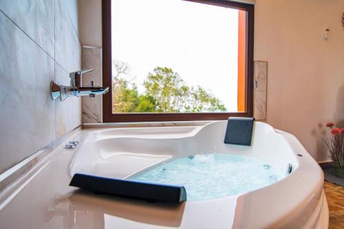 uma banheira branca com uma janela na casa de banho em Finca El Pastel em Tacoronte