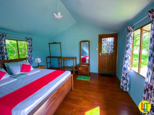 een slaapkamer met een groot bed met blauwe muren bij mango villa wilpattu in Nekattegama