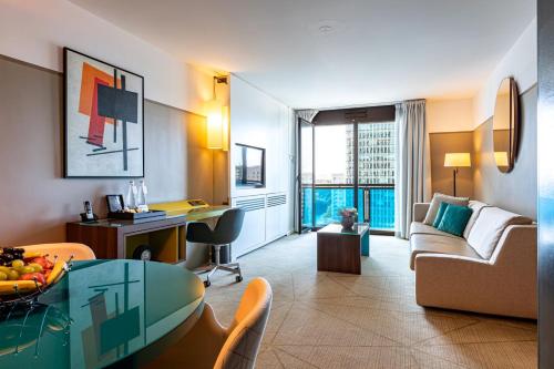 a living room with a couch and a table at Fraser Suites Paris La Défense in Courbevoie