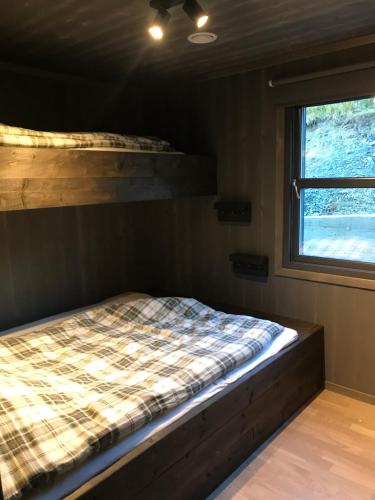 łóżko w pokoju z oknem w obiekcie Vangslia, Oppdal. Lekker leilighet med ski inn/ski ut w mieście Oppdal