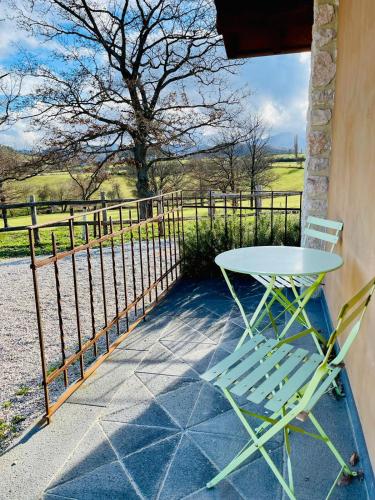 a table and chairs sitting on a porch with a fence at Agriturismo Casale Montebello in Monteleone di Spoleto