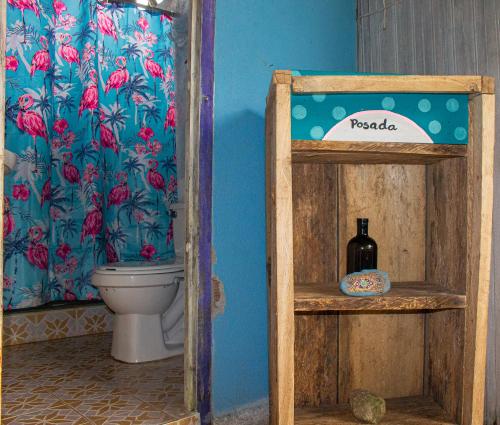 a bathroom with a toilet and a shower curtain at Hostal Bahía Solano Herping in El Valle