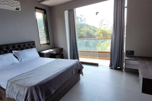 a bedroom with a bed and a large window at RK island view villa in Dabolim