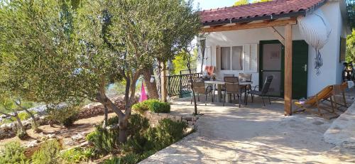 a house with a porch with a table and chairs at Robinson house Kata in Milna