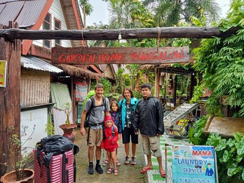 a family standing in front of a garden home bungalow at P P Garden Home Bungalow in Phi Phi Don