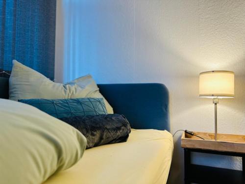 a bed with a pillow and a table with a lamp at Quartier48 - 2 Stadtapartments oder das ganze Haus bis 9 Personen in Suhl