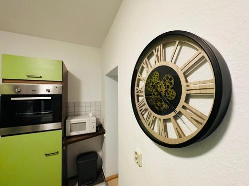 a large clock on the wall of a kitchen at Quartier48 - 2 Stadtapartments oder das ganze Haus bis 9 Personen in Suhl