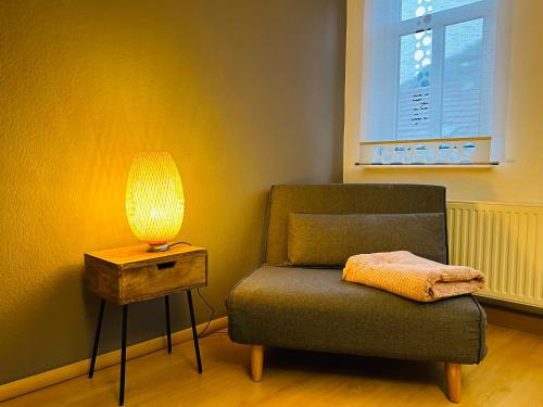 a lamp sitting next to a chair next to a table at Quartier48 - 2 Stadtapartments oder das ganze Haus bis 9 Personen in Suhl