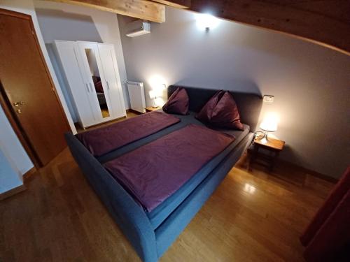 a bedroom with a bed with purple sheets and two lamps at Casa Giulia in Grado