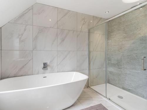 uma casa de banho com uma banheira branca e um chuveiro em Ty Afon Reg - Uk38509 em Garnant