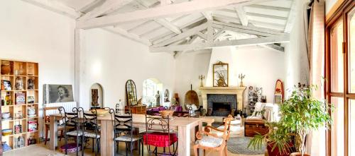 sala de estar con mesa, sillas y chimenea en La Bastide de la Provence Verte, chambres d'hôtes, en La Roquebrussanne