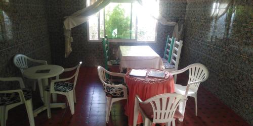 Zimmer mit einem Tisch, Stühlen und einem Fenster in der Unterkunft Fertassa mtls in Moulay Idris