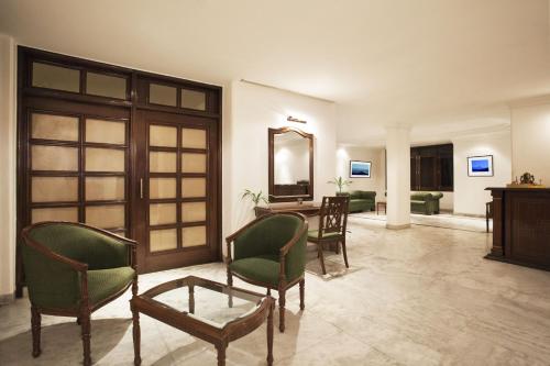 哈里瓦的住宿－阿爾帕納酒店，客厅配有椅子、桌子和镜子