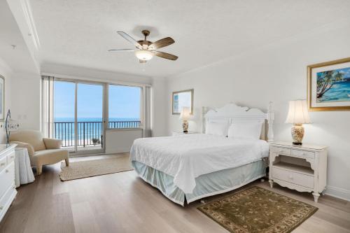 um quarto branco com uma cama e uma grande janela em Hidden Dunes 405 em Panama City Beach