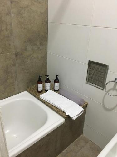 a bathroom with a sink and a bath tub at Real .Departamento in Luján