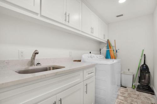 uma cozinha branca com um lavatório e uma máquina de lavar louça em Hidden Dunes 405 em Panama City Beach