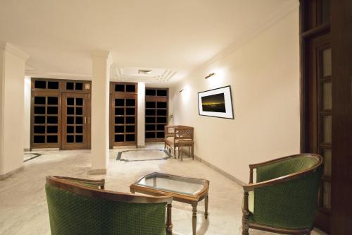 a living room with a table and chairs at Hotel Alpana in Haridwār