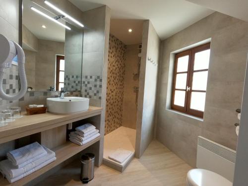 a bathroom with a sink and a mirror at Beaune Hôtel in Beaune