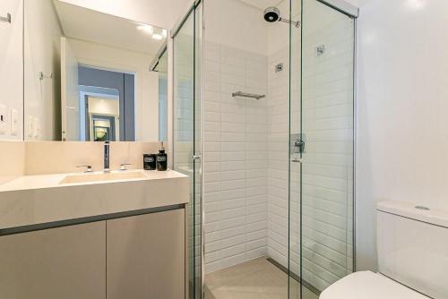 y baño con ducha acristalada y lavamanos. en K-Platz 406 - Studio Elegante e Moderno na Melhor Localização do Continente en São José