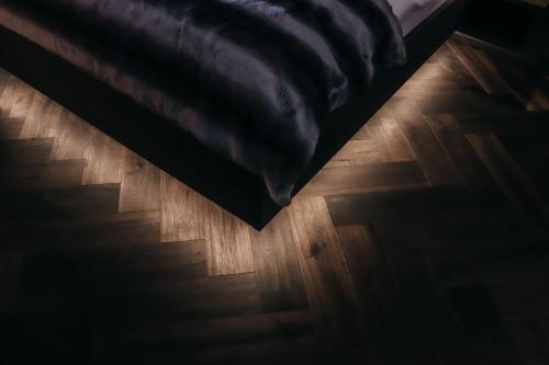 a bedroom with a bed and a wooden floor at ONKL XONNA Premium Alpin Chalets in Hüttschlag