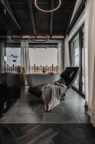 a bathroom with a bath tub and a large window at ONKL XONNA Premium Alpin Chalets in Hüttschlag
