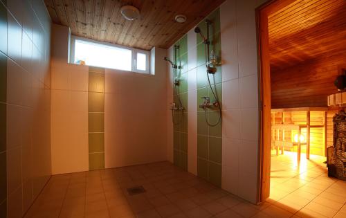 ein Bad mit einer Dusche und einem Fenster in der Unterkunft Roograhu guesthouse&resto in Hiiessaare