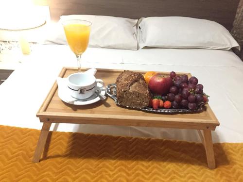 a tray of fruit on a table next to a bed at HOTEL PIACENTINI in Campo Mourão