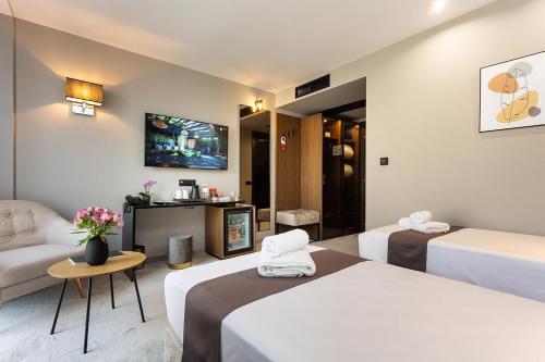 a hotel room with two beds and a tv at Abrazo Sofia Hotel by HMG in Sofia